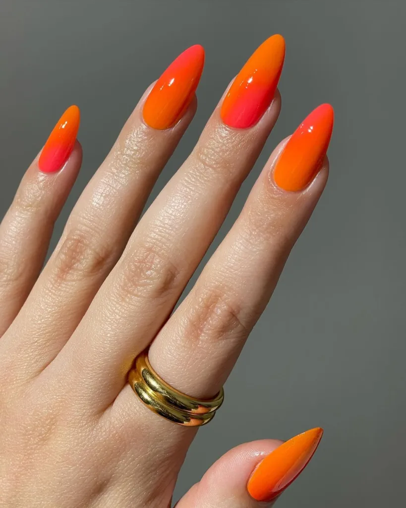 Vibrant orange-to-pink gradient nails for a bold statement.
