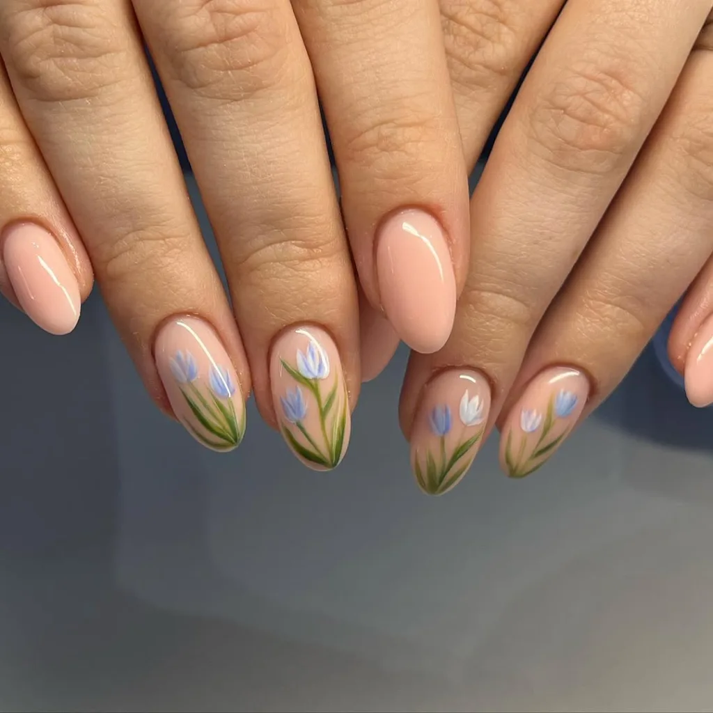 Peachy-pink nails with delicate blue tulip floral art.