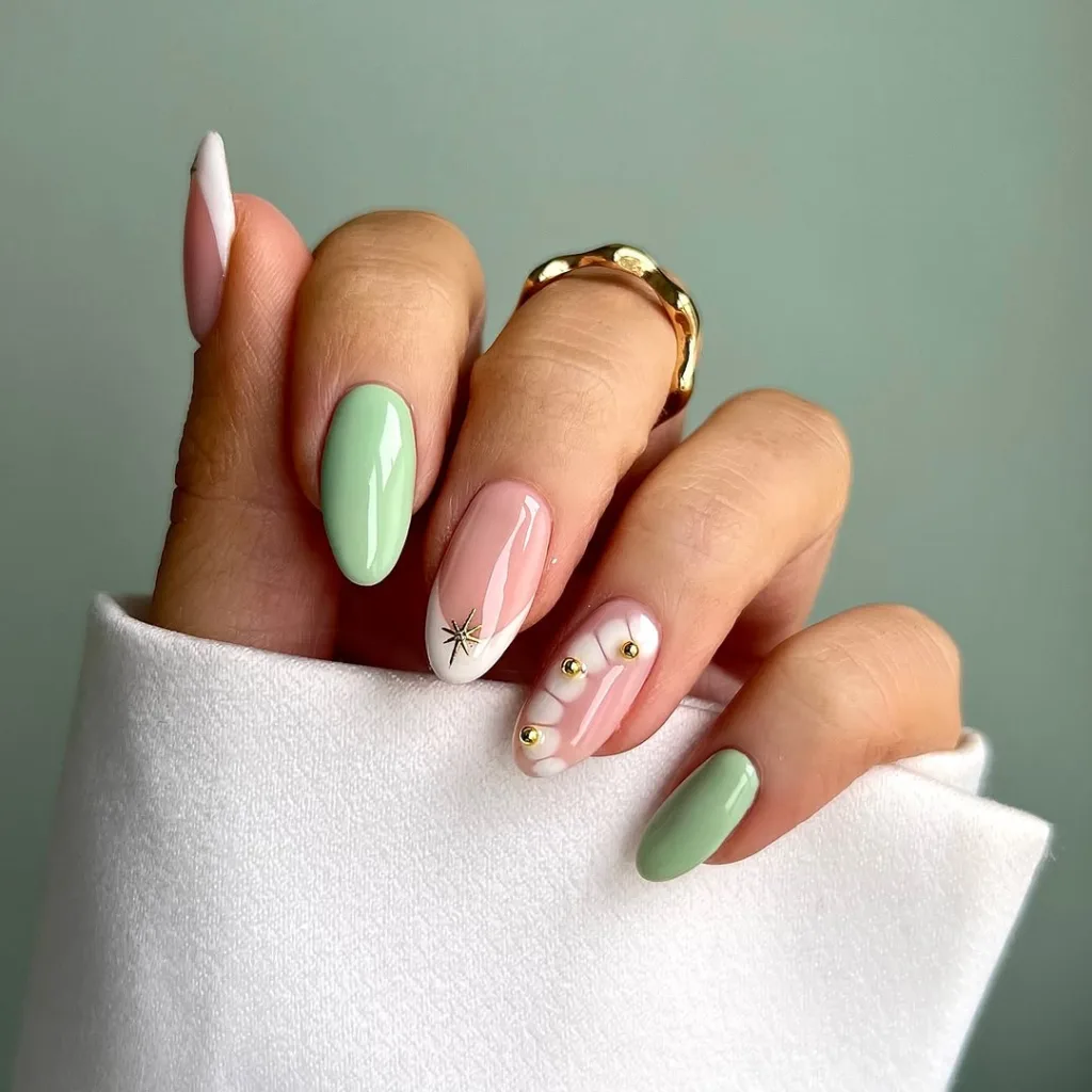 Mint green and pink abstract nails with gold accents.