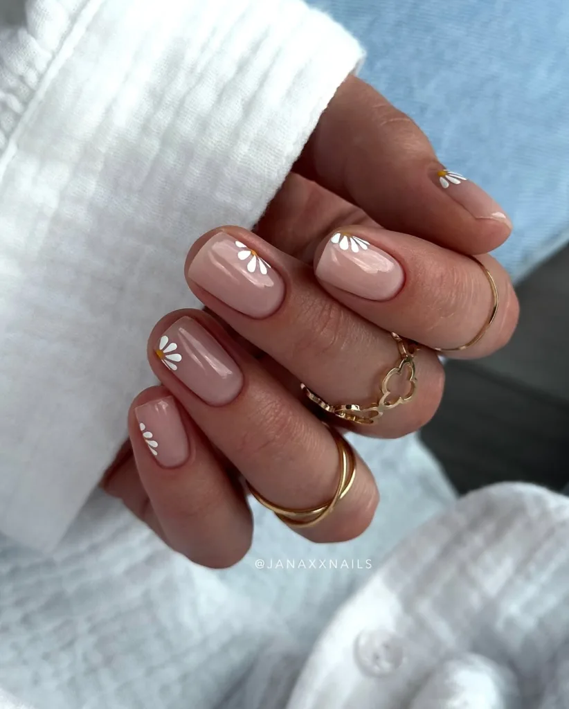 Transparent nails with minimal white daisy flowers, ideal for a soft spring look.