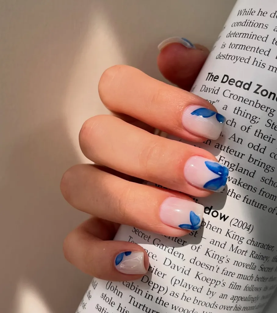 Transparent nails with delicate blue butterfly tips for a dreamy spring vibe.